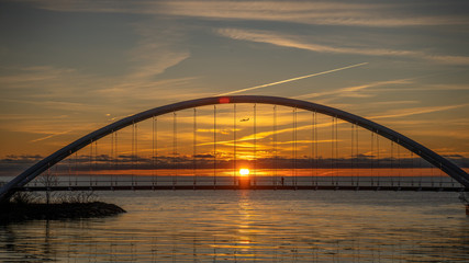 Fototapeta na wymiar sunrise behind bridge with plane