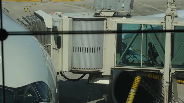 Telescopic gangway, sleeve, aerobridge in plane in airport. passengers boarding plane to flight on aircraft in departure gate terminal in airport. Board travel, tourism, tourist, vacation, 4 K slow-mo