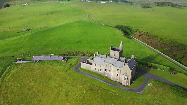 Classiebawn Castle in scenic rural landscape in Ireland, high angle aerial circle pan
