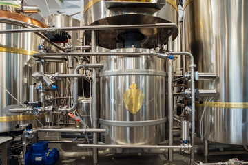 Stainless steel brewing tanks and equipment, iron reservoirs and pipes in modern beer factory