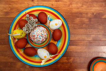 Easter cake with painted eggs on a table made of natural wood.