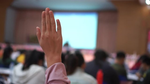 Audience or students raising hands up participation while speaker speech at seminar conference hall with crowd groups, arms of large group in classroom, Rear view of anonymous people vote or question