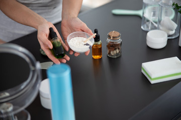 Young woman holding vitamin serum and cosmetic clay