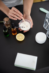 Young lady preparing cosmetic clay for mask