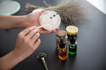 Young woman preparing white clay for mask