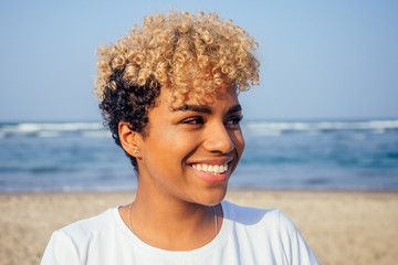 latin hispanic woman with perfect skin and curly afro hair enjoying at the beach
