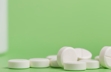 White round medicine pills. Green homogeneous background. At the top of the photo place for a banner.