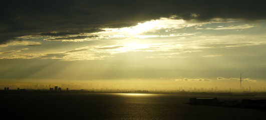 Tokyo skyline with sunlight peeking through the clouds