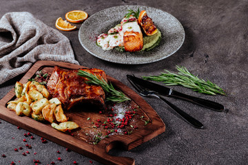 Beef and salmon steaks on the grill with flames top view