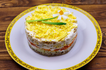 Traditional russian layered salad Mimosa with spring decoration Daffodil. Decoration is made of egg, green onion and carrot