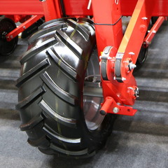 Red metal support with a large wheel.