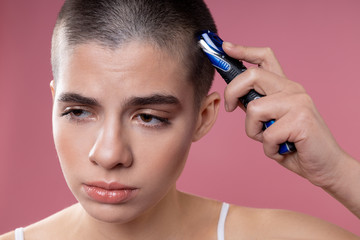 Upset young lady shaving her hair stock photo
