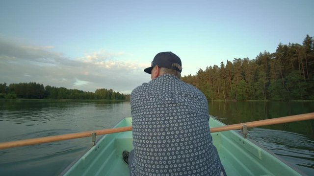 POV of man rowing boat on calm lake, pov rear wide shot, Suwalszczyzna, Poland