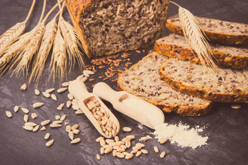 Bread for breakfast, ingredients for baking and ears of rye or wheat grain. Vintage photo