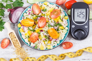 Glucometer for analyzing sugar level and salad with bulgur groats and vegetables. Diabetes, slimming and healthy lifestyles and nutrition