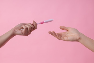 Girl giving tampon in applicator to her friend stock photo - obrazy, fototapety, plakaty