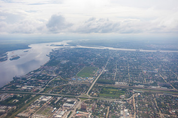 View from above. The border city of Blagoveshchensk from an airplane window. A bridge over the Amur River, connecting Russia and China.