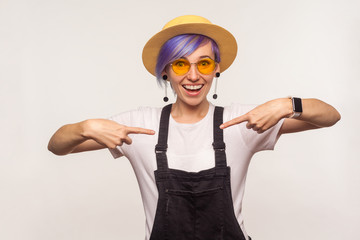 Choose me! Portrait of proud hipster girl with violet hair in glamour glasses and fashionable clothes pointing herself enjoying success, boasting achievement. isolated on white background, studio shot