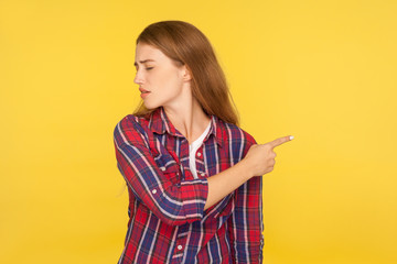 Conflict and breakup. Portrait of irritated ginger girl in checkered shirt turning away and showing gesture get out, asking to leave, feeling betrayed. indoor studio shot isolated on yellow background