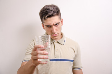 Young man offering a glass of water 