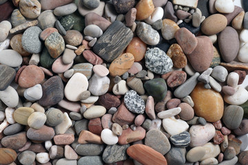Gravel pattern of colored stones. Abstract nature pebbles background.Small sea stones on the beach, vacation at sea. Top view      