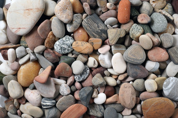 Gravel pattern of colored stones. Abstract nature pebbles background.Small sea stones on the beach, vacation at sea. Top view      