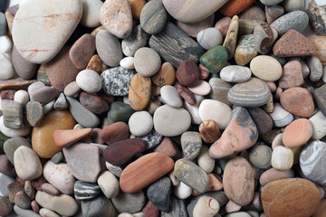 Gravel pattern of colored stones. Abstract nature pebbles background.Small sea stones on the beach, vacation at sea. Top view      
