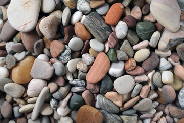 Gravel pattern of colored stones. Abstract nature pebbles background.Small sea stones on the beach, vacation at sea. Top view      