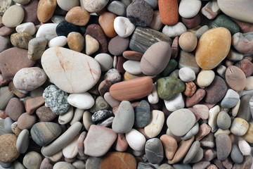 Gravel pattern of colored stones. Abstract nature pebbles background.Small sea stones on the beach, vacation at sea. Top view      