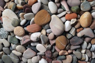 Gravel pattern of colored stones. Abstract nature pebbles background.Small sea stones on the beach, vacation at sea. Top view      