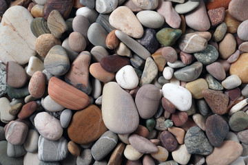 Gravel pattern of colored stones. Abstract nature pebbles background.Small sea stones on the beach, vacation at sea. Top view      