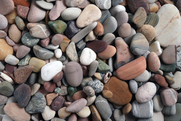 Gravel pattern of colored stones. Abstract nature pebbles background.Small sea stones on the beach, vacation at sea. Top view      