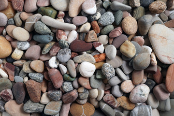 Gravel pattern of colored stones. Abstract nature pebbles background.Small sea stones on the beach, vacation at sea. Top view      
