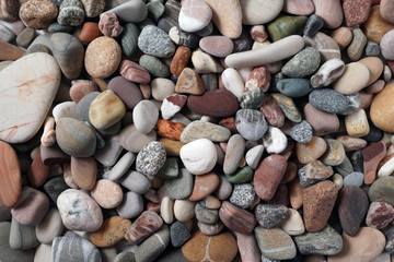Gravel pattern of colored stones. Abstract nature pebbles background.Small sea stones on the beach, vacation at sea. Top view      