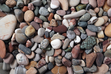 Gravel pattern of colored stones. Abstract nature pebbles background.Small sea stones on the beach, vacation at sea. Top view      