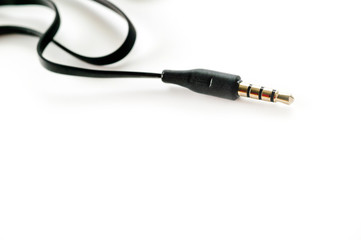 3.5 mm plug with a black wire, shot large on a white background. Background for music and computer equipment.
