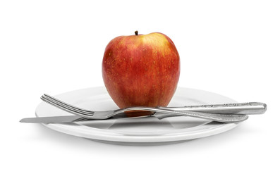 Red apple with fork and knife on white plate. Isolated on white. Healthy eating and dieting concept.