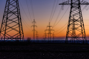 High voltage power line in a field at sunset
