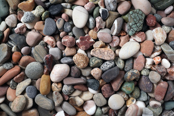 Gravel pattern of colored stones. Abstract nature pebbles background.Small sea stones on the beach, vacation at sea. Top view      