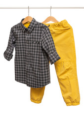 Yellow toddler-boy (trousers) pants and  shirt with long sleeves hanging on shoulders isolated on white background for spring and autumn wardrobe/ Сhildren's wear/ Close-up