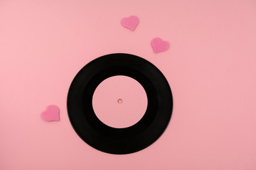 retro dusty vinyl disc with favorite songs and pink hearts on a pink background