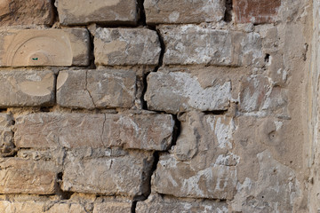 Rough brick wall background with a crack closeup