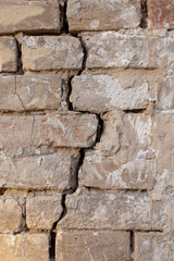 Rough brick wall background with a crack closeup