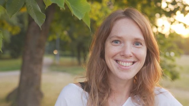 portrait of a happy red-haired girl on a Sunny day