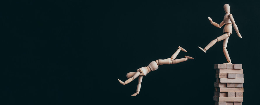 Authoritarian leadership. Strength power. Articulated man kicking down wooden mannequin.