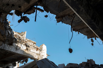Destruction of buildings. A huge gap in the concrete slab with concrete fragments hanging on the...