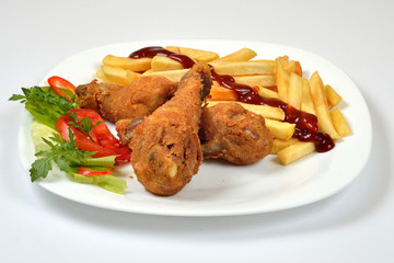 Food from a chicken restaurant with vegetables and sauce.