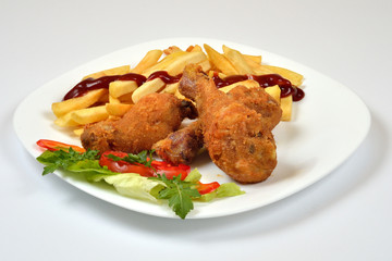 Food from a chicken restaurant with vegetables and sauce.