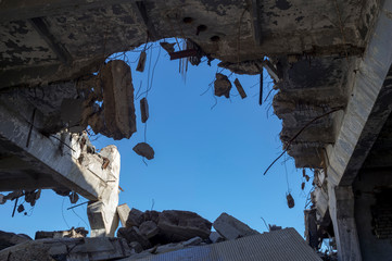 Destruction of buildings. A huge gap in the concrete slab with concrete fragments hanging on the rebar. Background