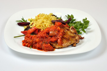 Food from a chicken restaurant with vegetables and sauce.